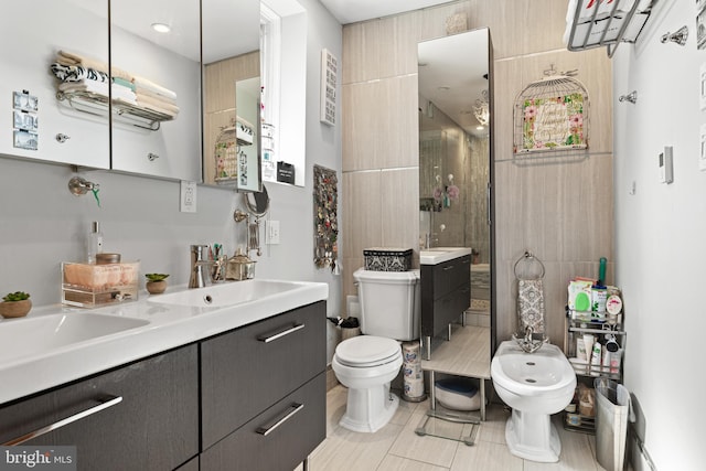 bathroom featuring tiled shower, tile patterned floors, toilet, a bidet, and vanity