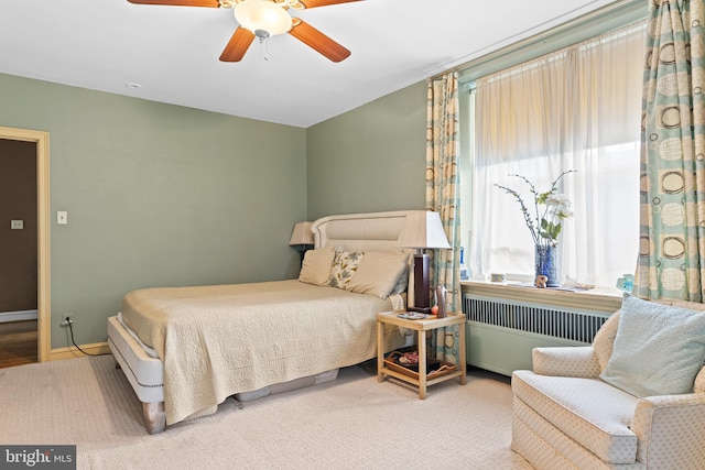 bedroom featuring light carpet, radiator heating unit, and ceiling fan