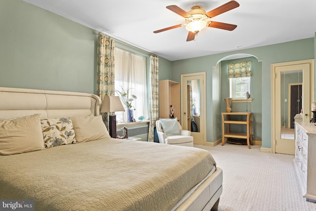 carpeted bedroom featuring multiple windows and ceiling fan