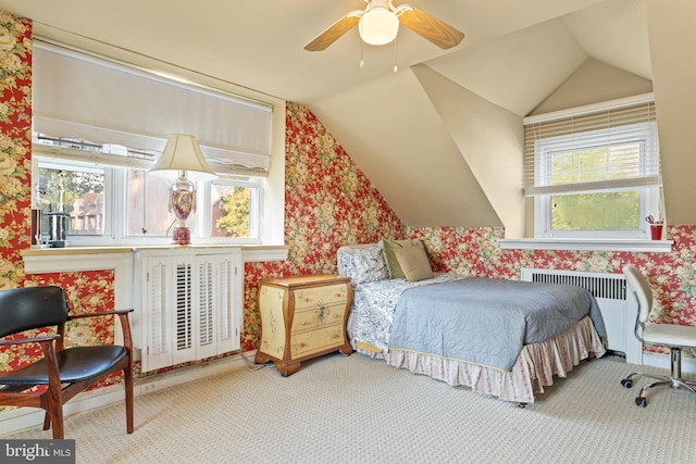 bedroom featuring radiator, ceiling fan, vaulted ceiling, and multiple windows