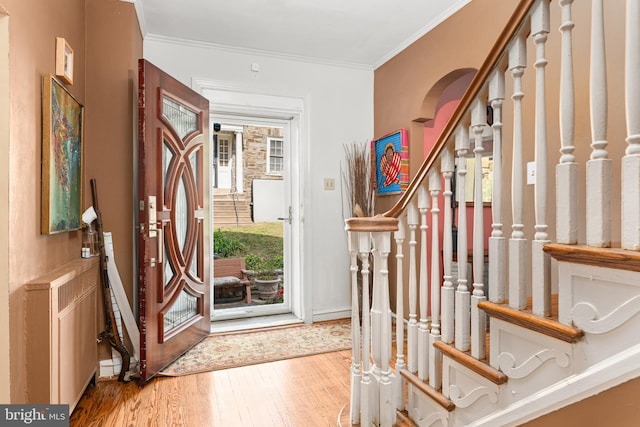 foyer entrance featuring crown molding and hardwood / wood-style floors