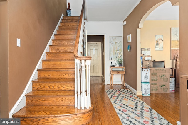 stairway featuring crown molding and wood-type flooring