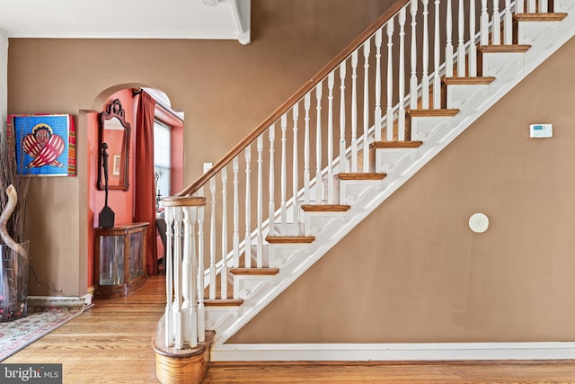 stairs featuring crown molding and wood-type flooring