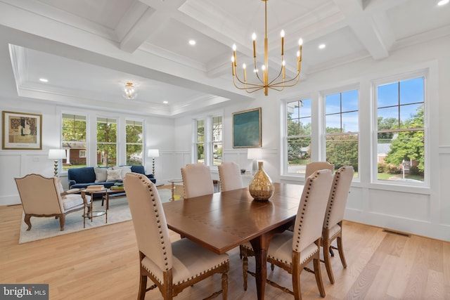 dining space with a wealth of natural light, a decorative wall, visible vents, and coffered ceiling