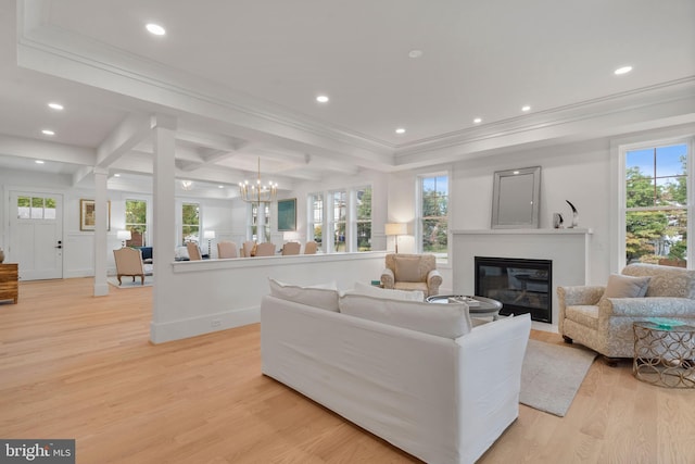 living room with plenty of natural light, crown molding, and light wood-type flooring