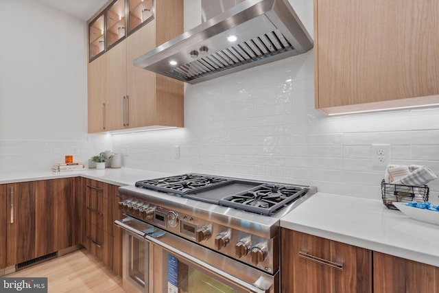 kitchen featuring visible vents, double oven range, light countertops, and wall chimney exhaust hood