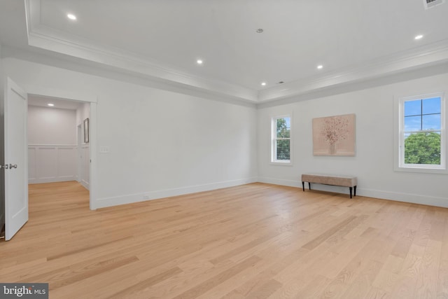 unfurnished room featuring recessed lighting, a raised ceiling, light wood-style floors, and crown molding