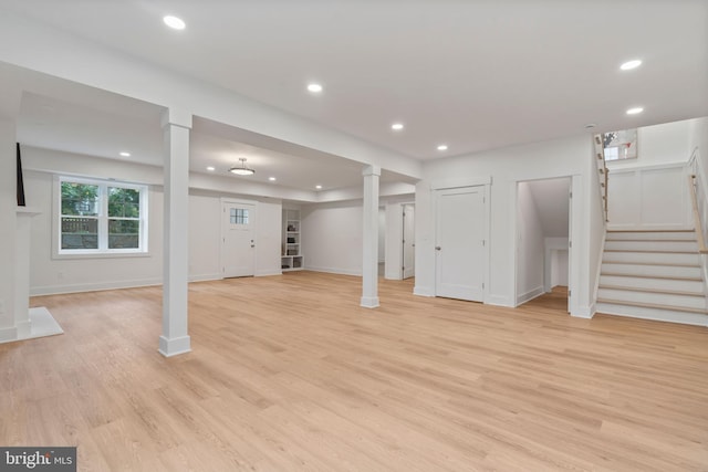 basement with recessed lighting, baseboards, light wood-style floors, and stairs