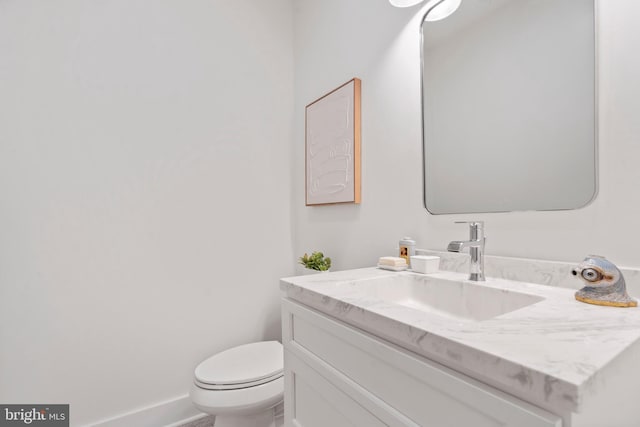 bathroom featuring vanity, toilet, and baseboards