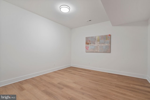 spare room featuring visible vents, light wood-type flooring, and baseboards