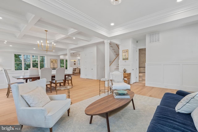 living room with ornamental molding, beam ceiling, coffered ceiling, and light wood-type flooring