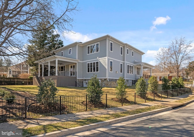 view of front facade featuring a fenced front yard, stone siding, a porch, a front yard, and ceiling fan