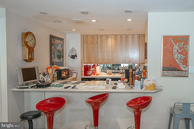 kitchen featuring a breakfast bar area and kitchen peninsula