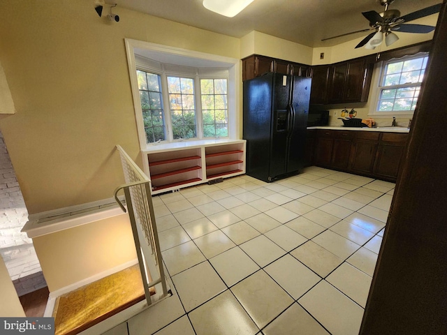 kitchen with black refrigerator with ice dispenser, dark brown cabinets, and a wealth of natural light