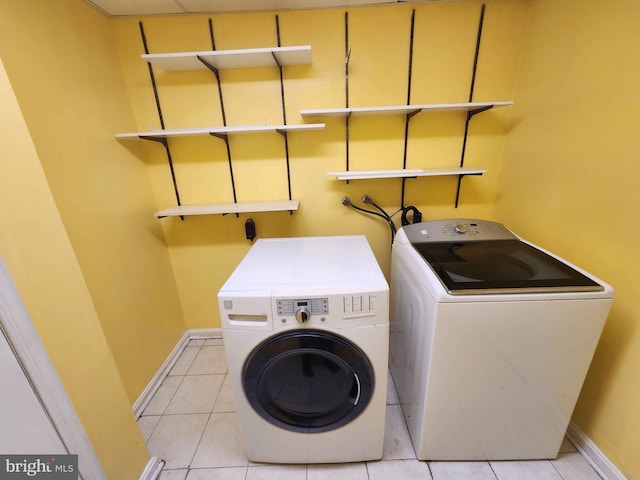 laundry area featuring light tile patterned floors and separate washer and dryer