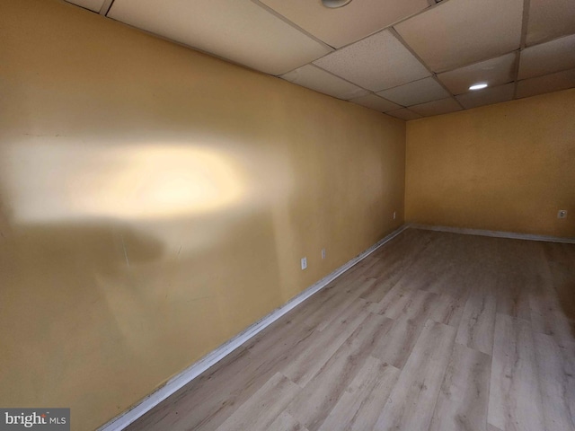 empty room featuring a drop ceiling and light wood-type flooring