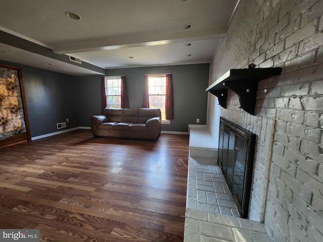 unfurnished living room with hardwood / wood-style flooring, beamed ceiling, and a fireplace