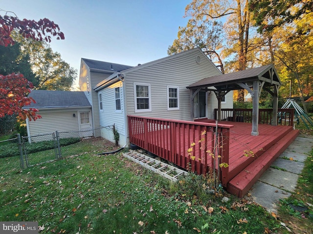 back of house featuring a gazebo, a wooden deck, and a yard