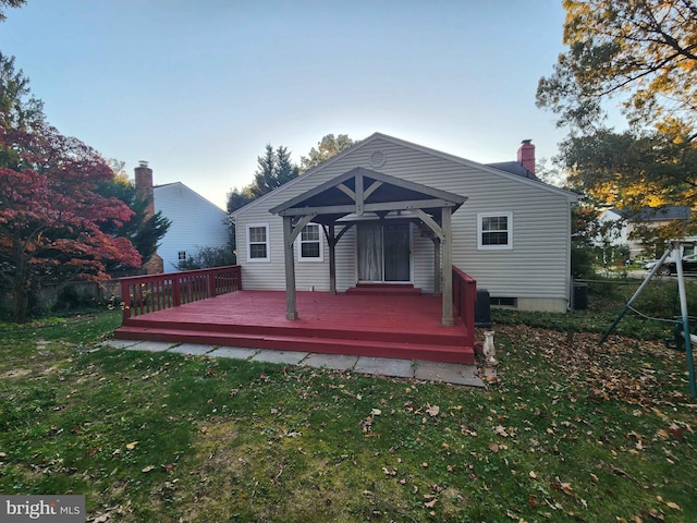 rear view of house with a wooden deck, a gazebo, and a yard