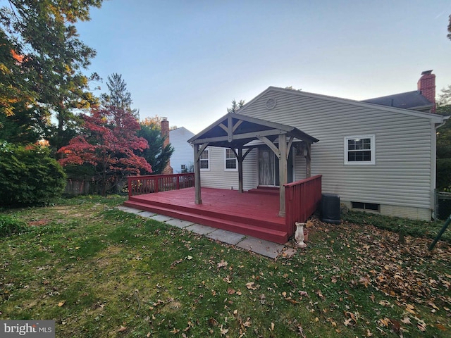 back of property featuring a gazebo, a deck, and a yard