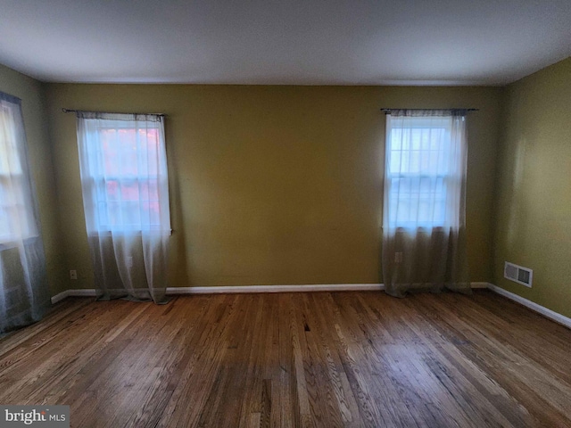 unfurnished room with dark wood-type flooring