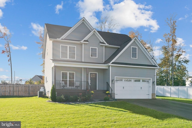 view of front of home with central AC, a front yard, a garage, and a porch