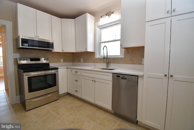 kitchen with sink, appliances with stainless steel finishes, and white cabinets