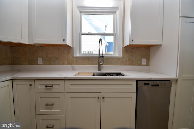 kitchen with white cabinets, light stone counters, backsplash, dishwasher, and sink