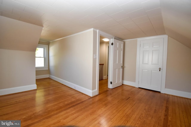 additional living space with vaulted ceiling and wood-type flooring