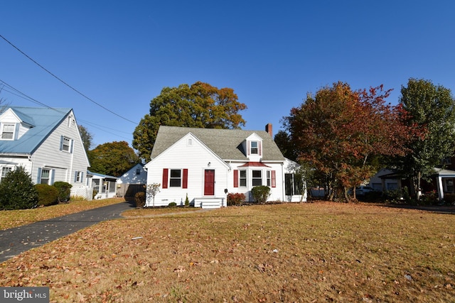 cape cod house featuring a front yard