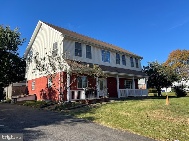 view of front of property with a porch and a front lawn