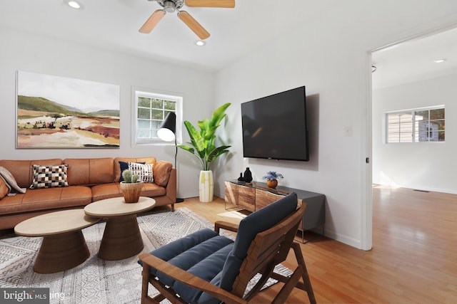 living room with light wood-type flooring and ceiling fan