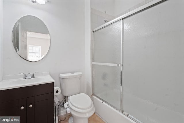 full bathroom with vanity, shower / bath combination with glass door, toilet, and tile patterned floors