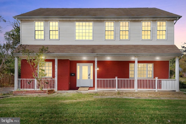 view of front of house with a porch and a lawn