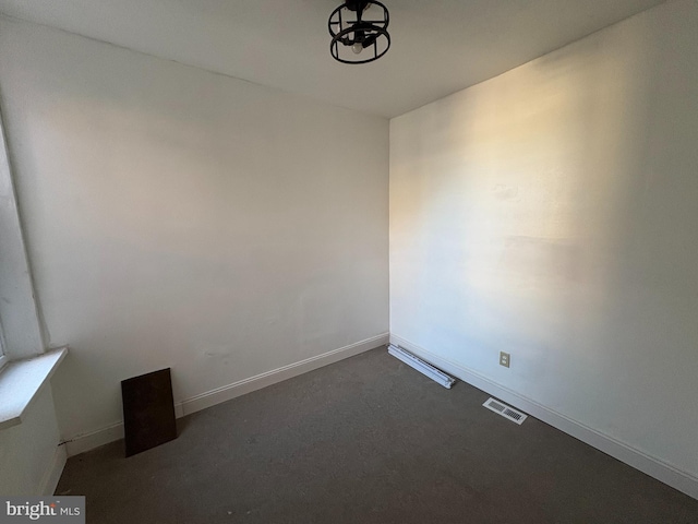 spare room with dark carpet