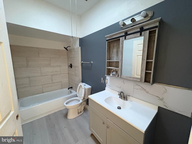 full bathroom featuring decorative backsplash, hardwood / wood-style floors, toilet, vanity, and tiled shower / bath combo