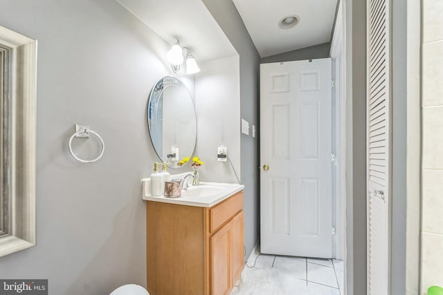 bathroom featuring tile patterned flooring, vanity, and vaulted ceiling