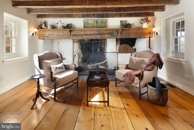 living area featuring light hardwood / wood-style floors and beamed ceiling