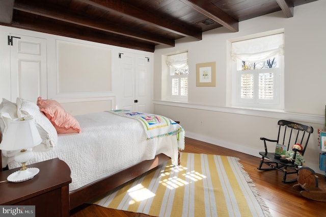 bedroom with wood ceiling, wood-type flooring, and beam ceiling