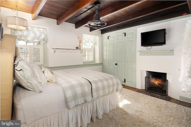 bedroom featuring hardwood / wood-style floors, beam ceiling, wood ceiling, and a closet