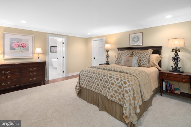 carpeted bedroom featuring crown molding and ensuite bathroom