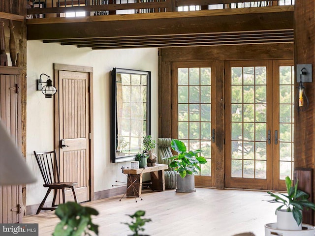 interior space with french doors, a wealth of natural light, hardwood / wood-style flooring, and radiator