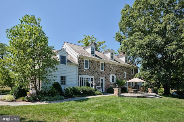 back of property with a patio and a lawn