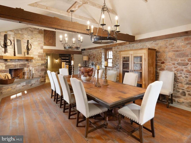 dining area featuring hardwood / wood-style flooring, an inviting chandelier, and lofted ceiling with beams