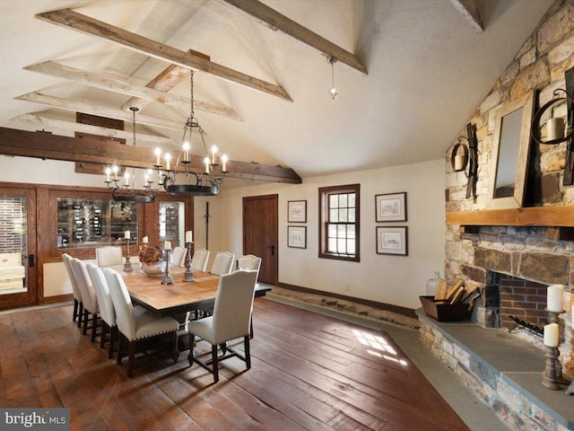 dining room with dark wood-type flooring, beamed ceiling, a notable chandelier, and a fireplace