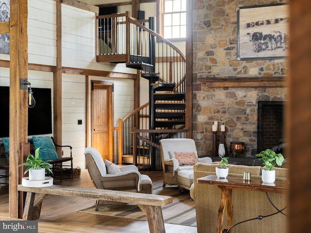 living room with wood walls, wood-type flooring, and a high ceiling