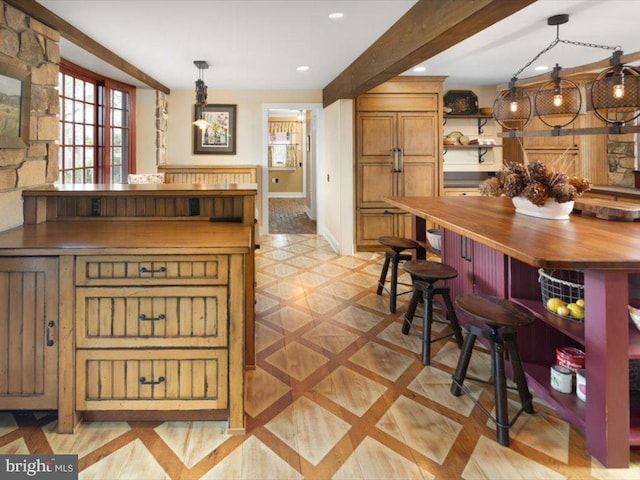 kitchen with butcher block counters, beam ceiling, and pendant lighting