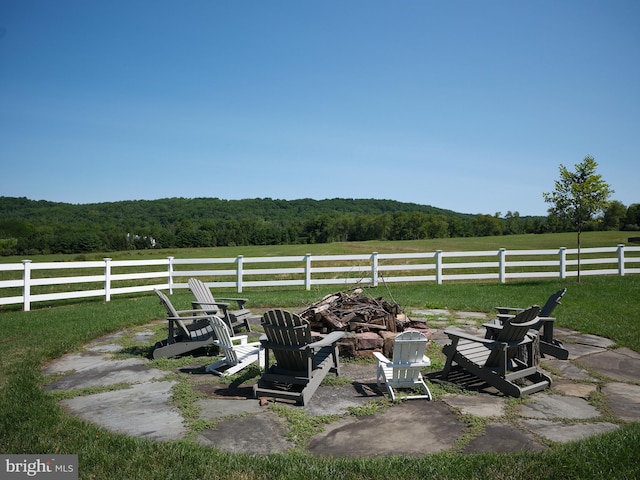 view of yard with a rural view, a fire pit, and a patio area