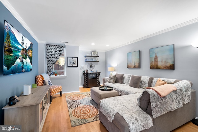 living room with ornamental molding and light hardwood / wood-style flooring