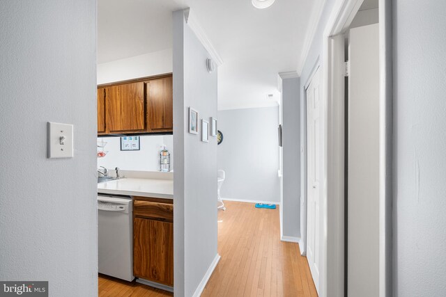 hall with ornamental molding, sink, and light wood-type flooring